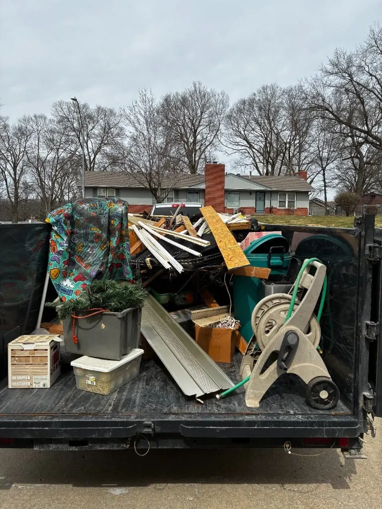 Loaded junk removal trailer outside a Platte City home